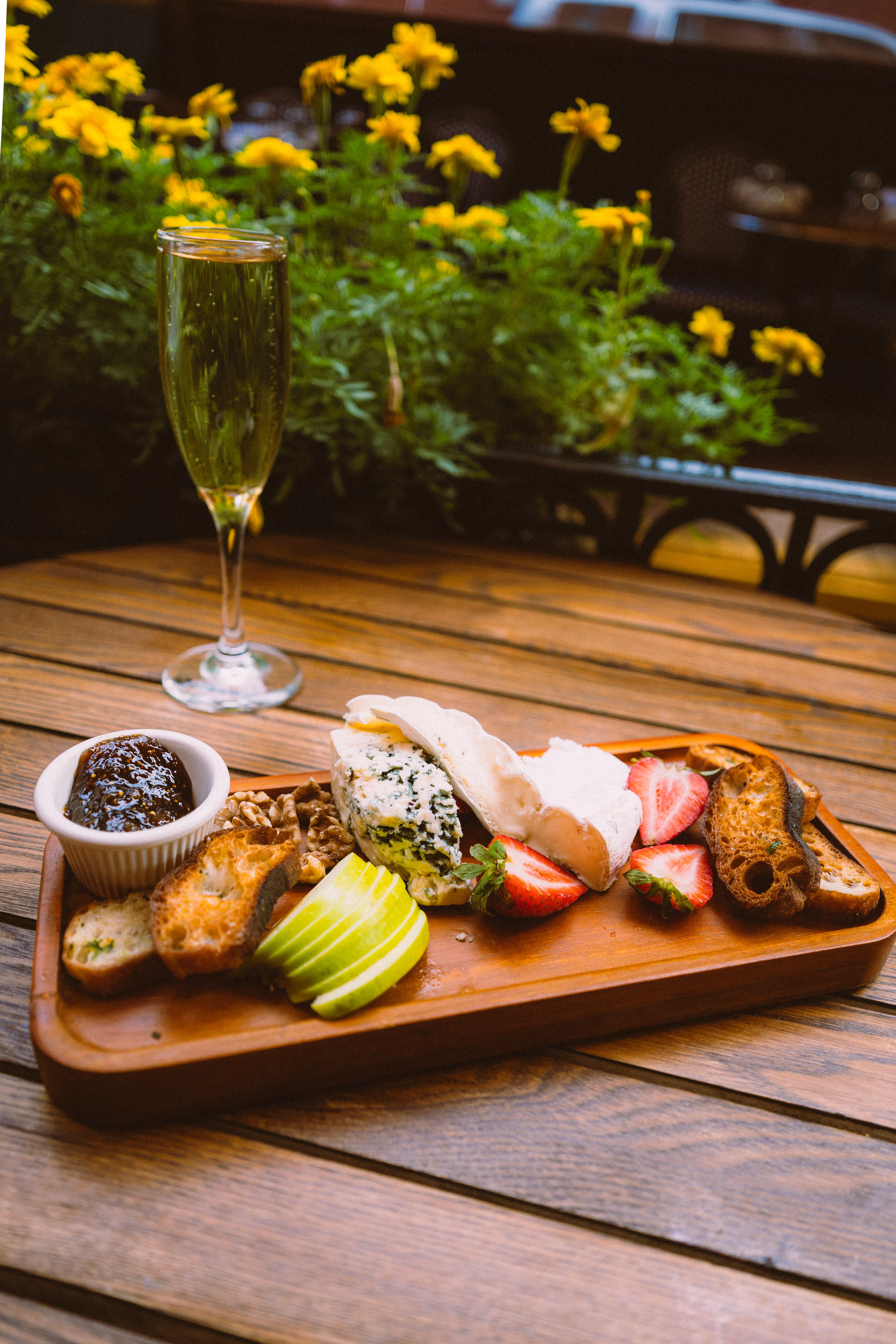 A cheese board and a glass of sparkling wine on the patio