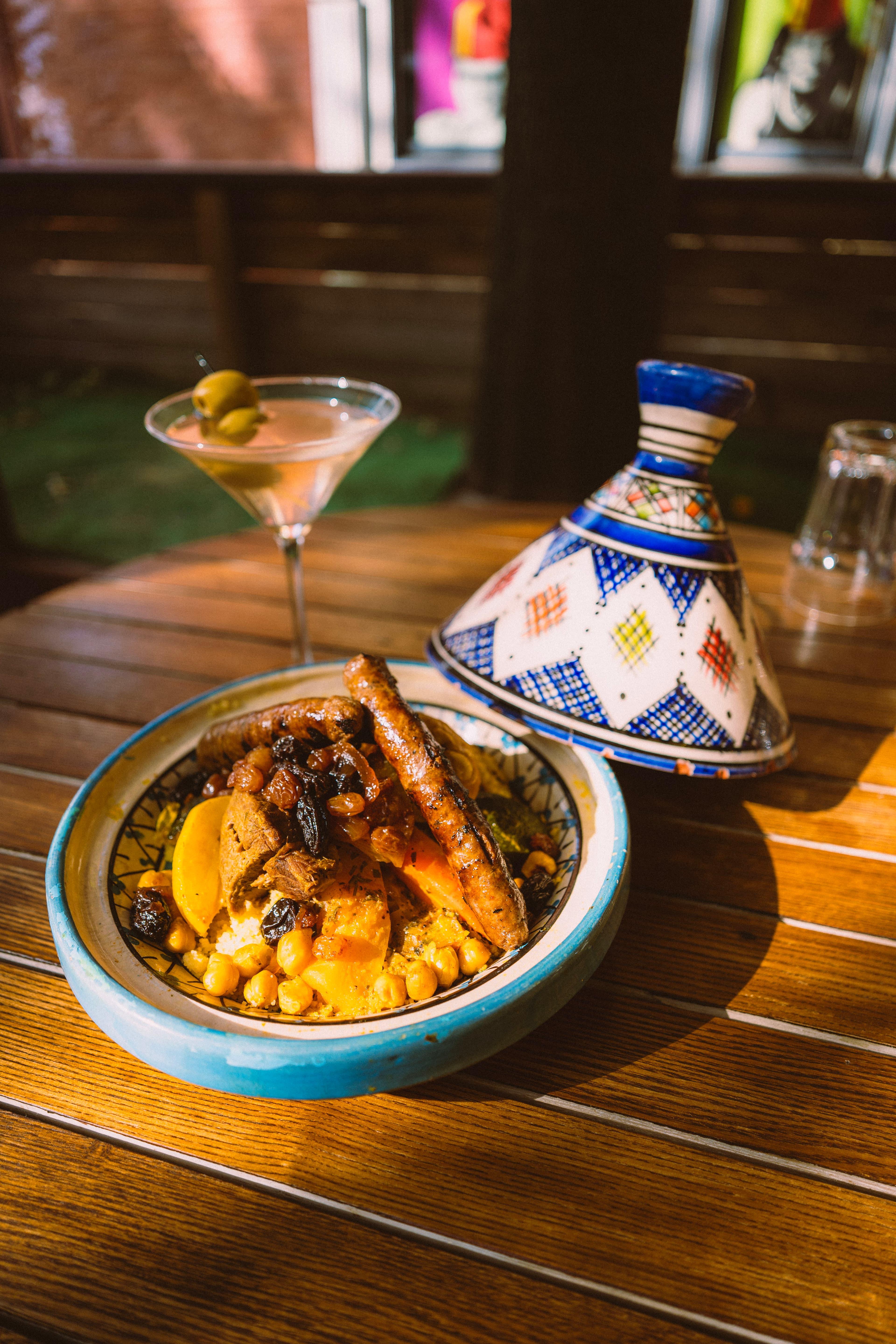 Couscous and merguez served with a martini and painted tagine lid