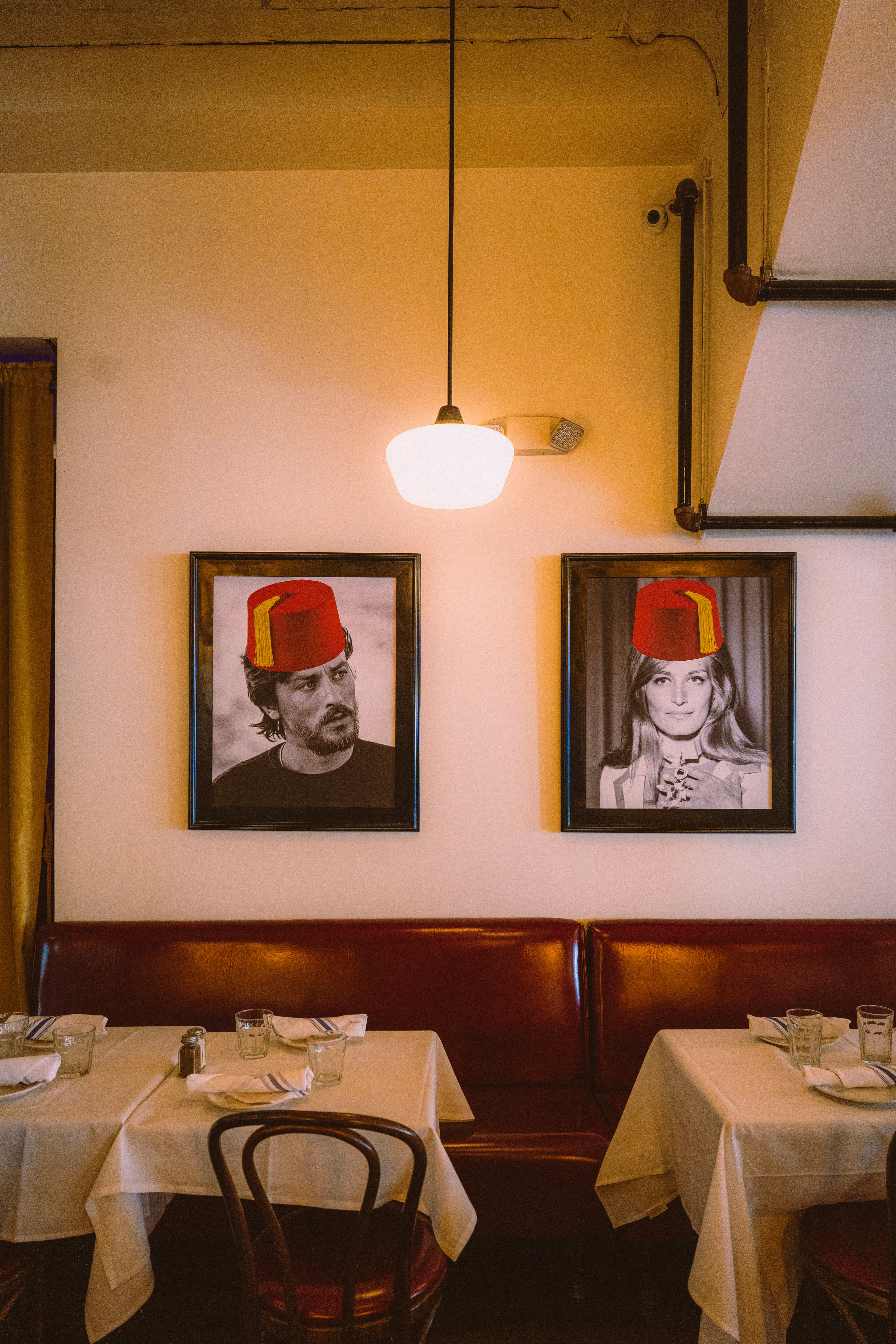 Framed portraits in red fezzes above the dining room booths