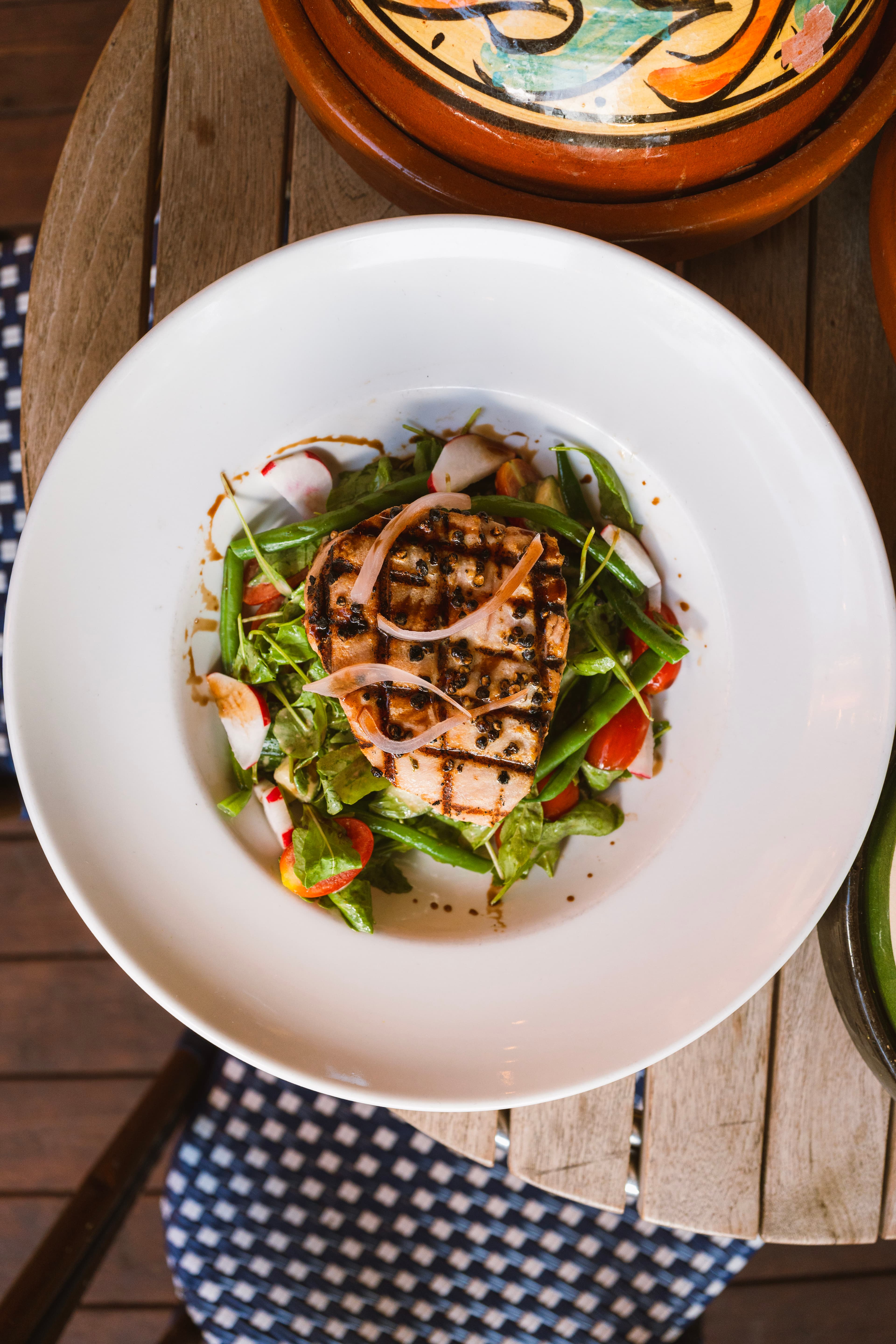 Grilled tuna salad with greens and tomatoes, seen from above