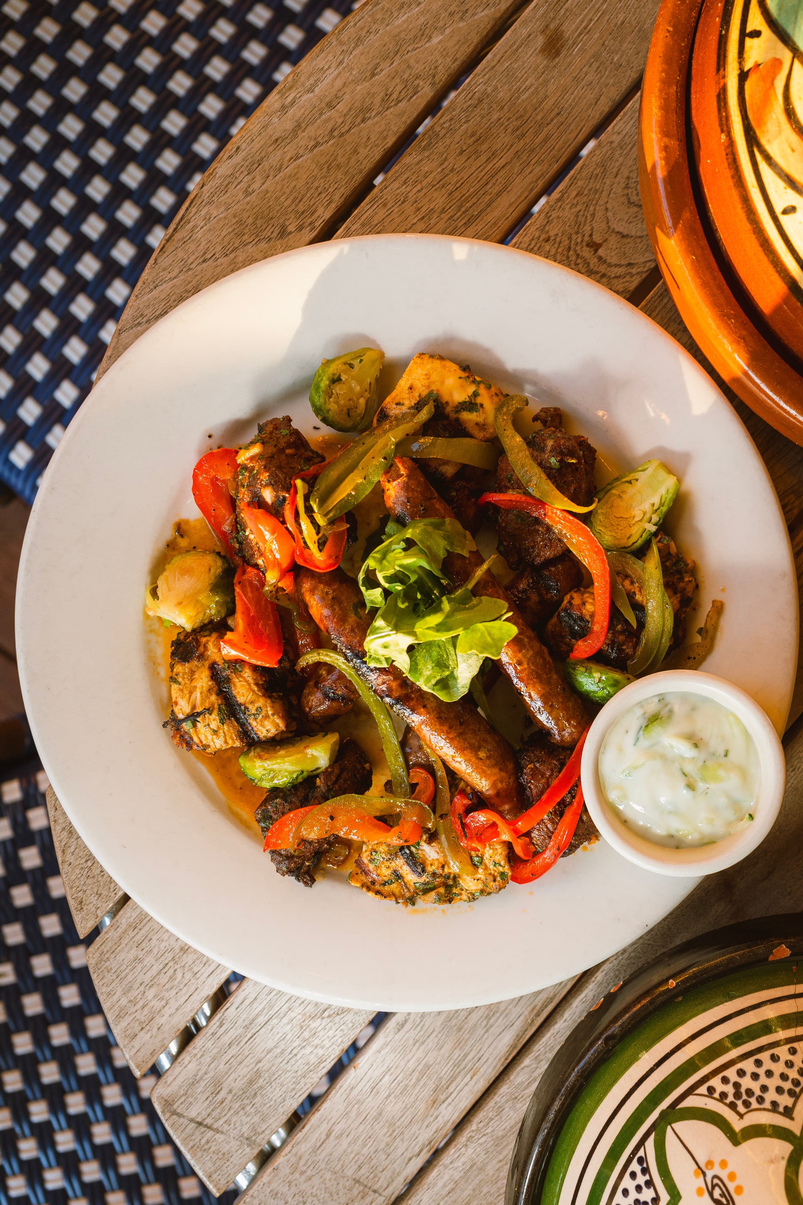 Merguez sausage plate with grilled vegetables and yogurt sauce
