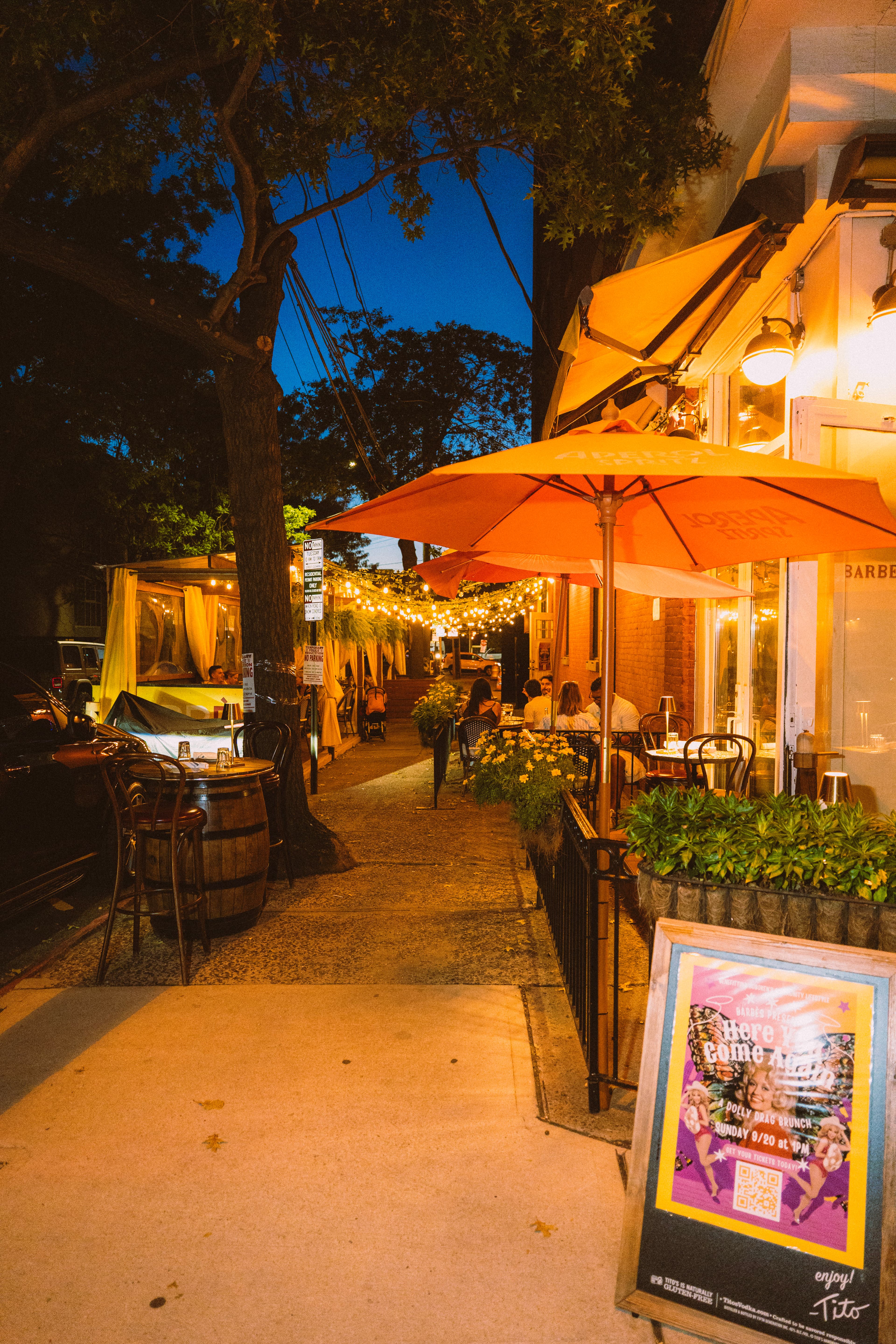 The Barbès sidewalk under string lights at dusk