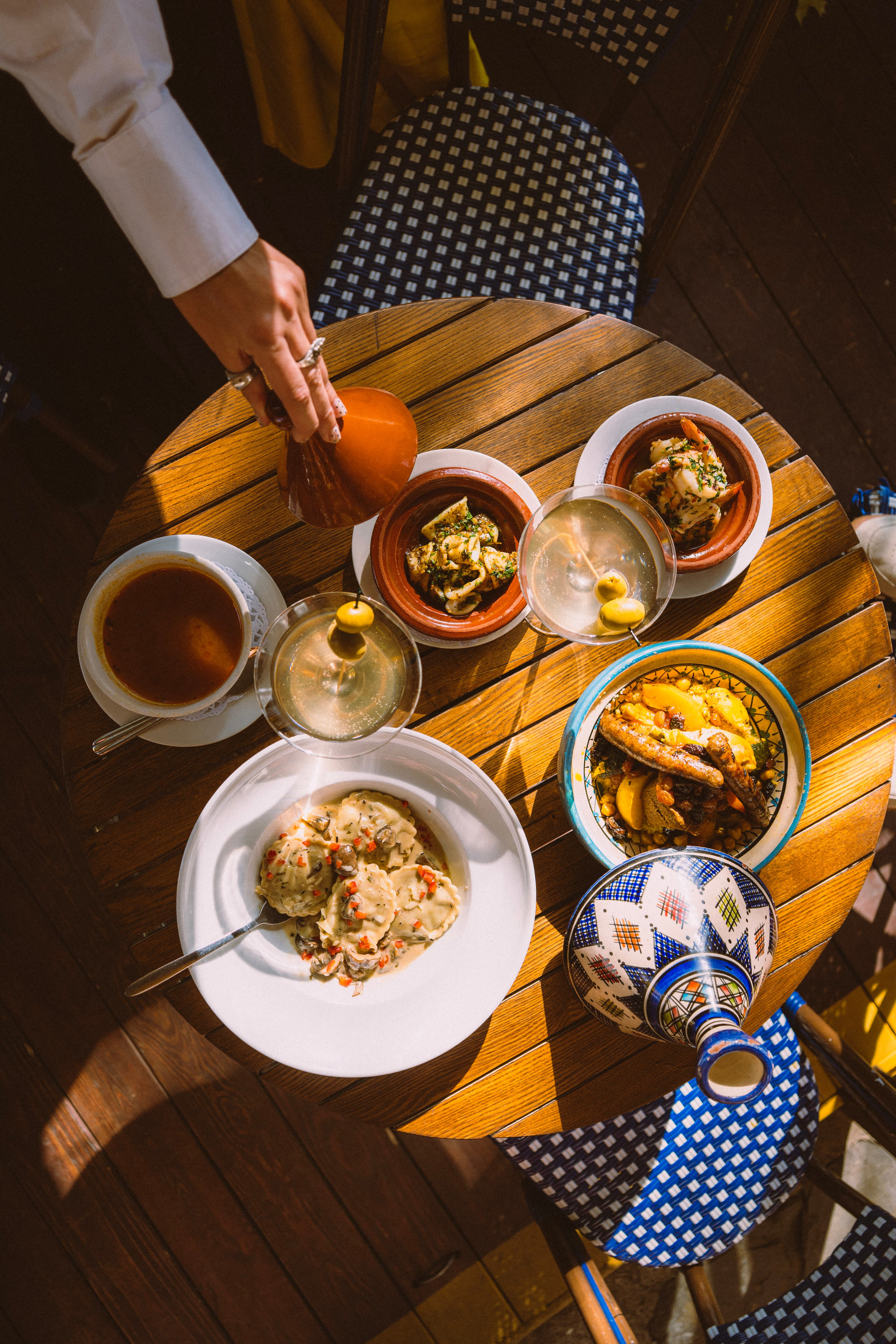 A table set with tea, tagines and a blue tagine pot, seen from above