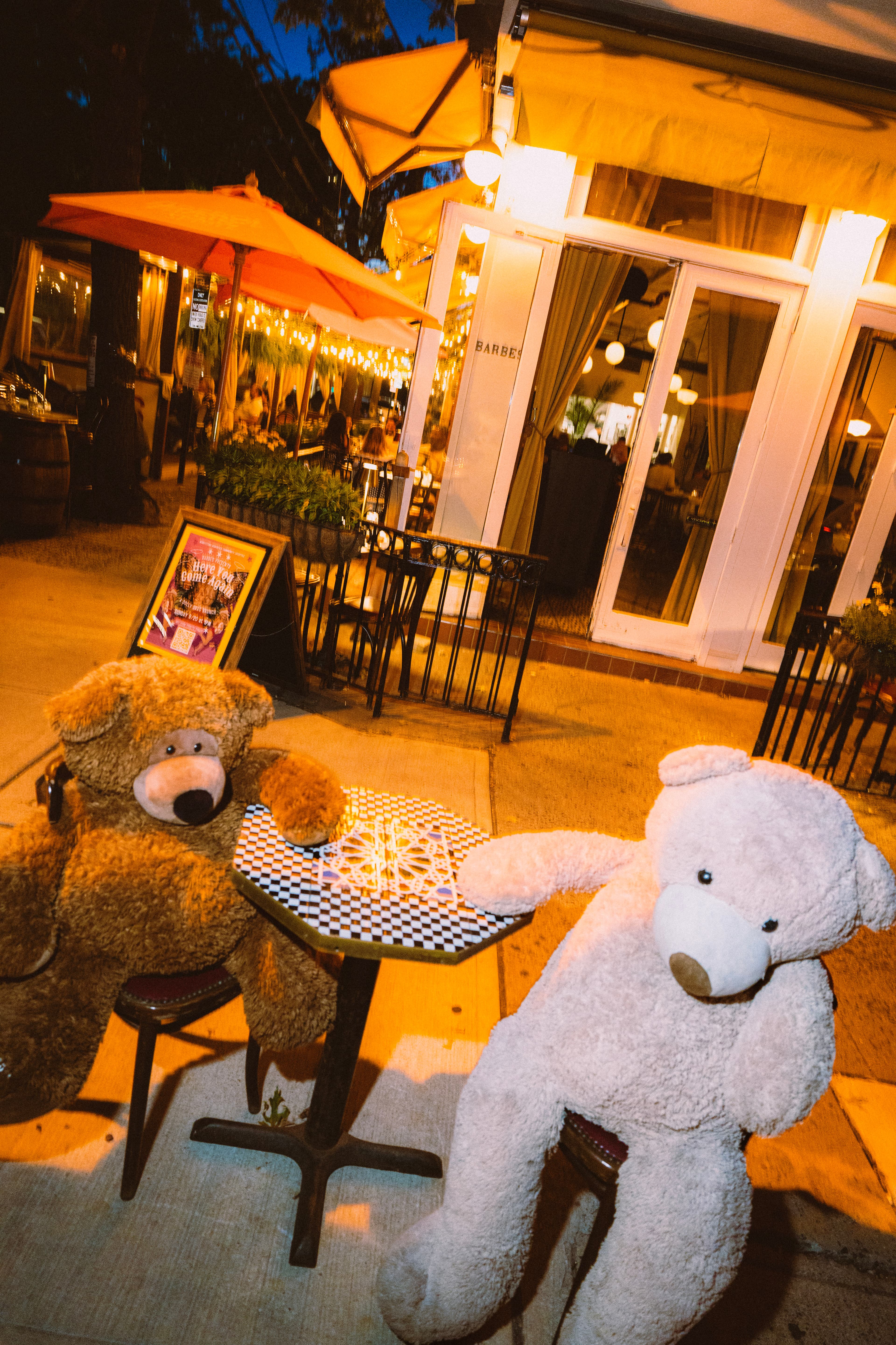 Giant teddy bears at a mosaic table on the Barbès patio